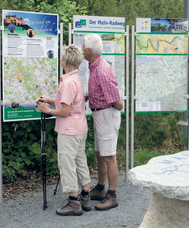 Zwei Wanderer betrachten die Karte des Wanderwegs